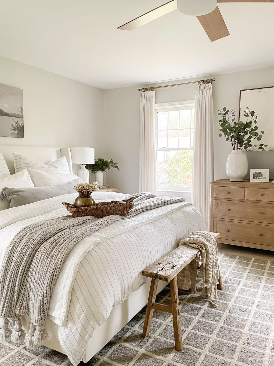 bedroom with classic gray walls, wood dresser and neutral toned bedding