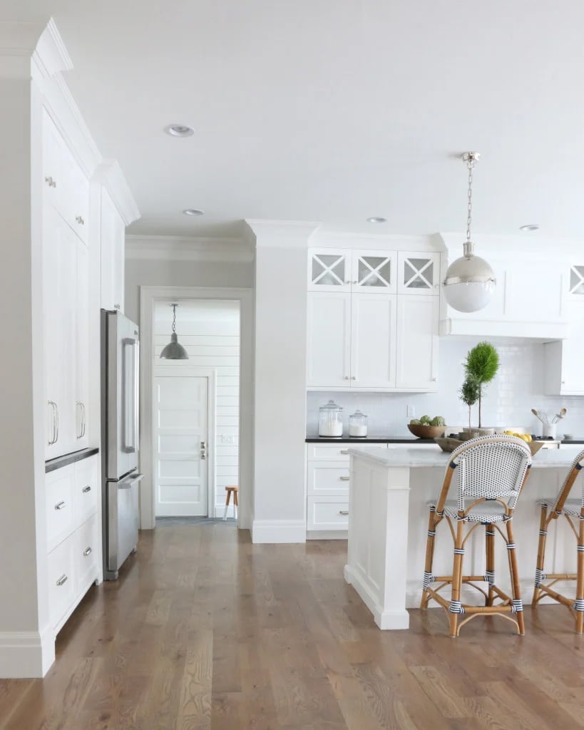 white kitchen cabinets with classic gray walls and warm wood floors