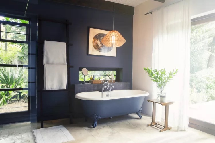 large bathroom with dark blue walls and tub. 