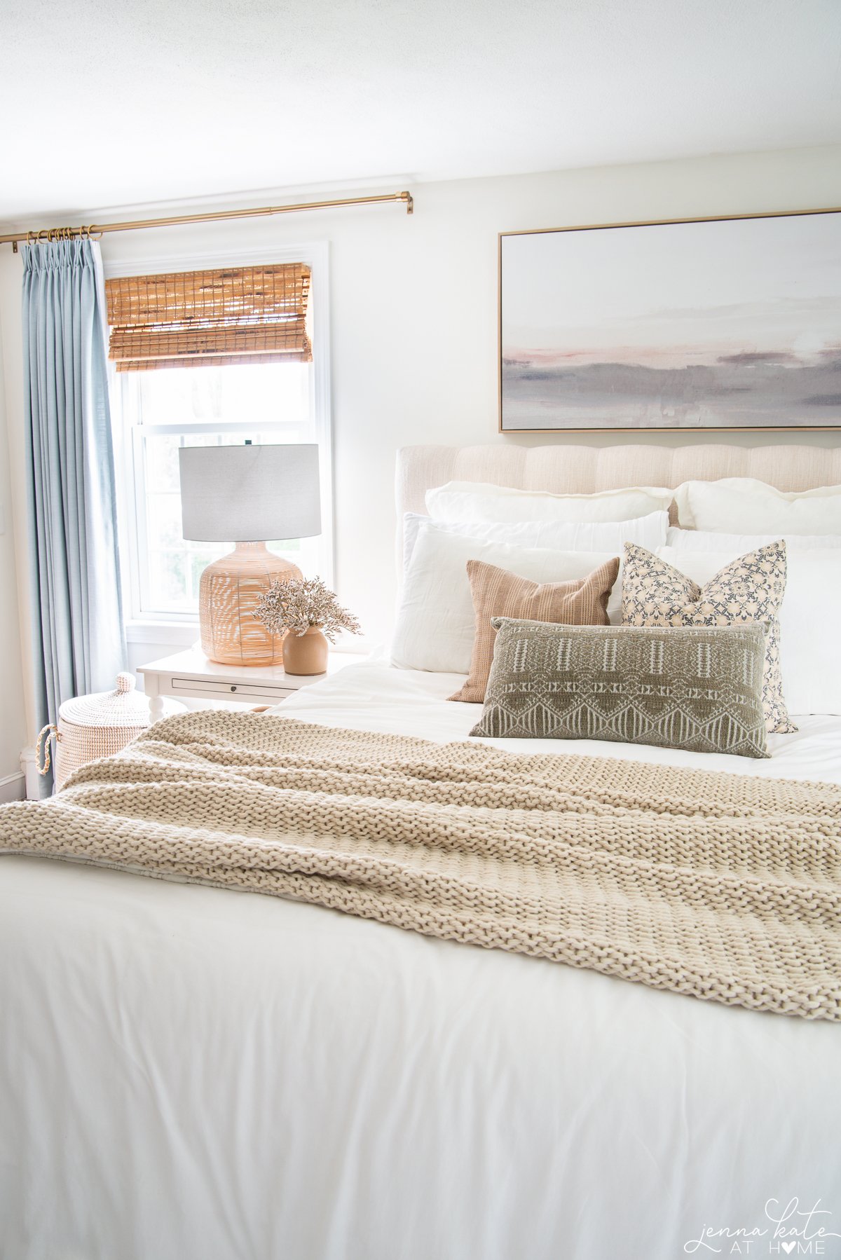 A coastal color scheme bedroom with three throw pillows arranged together on the bed.
