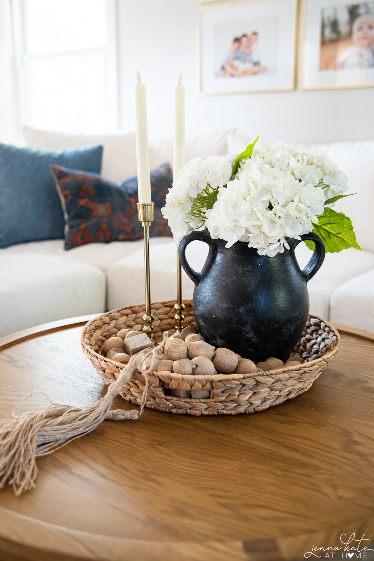 White Faux Flowers in a black vase displayed on a center coffee table.