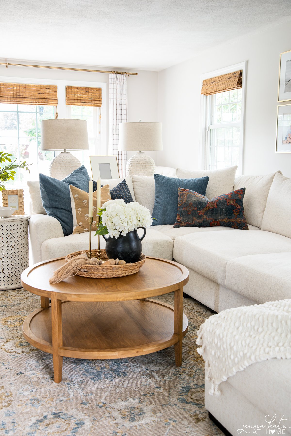 white couch with a wooden coffee table with black vase