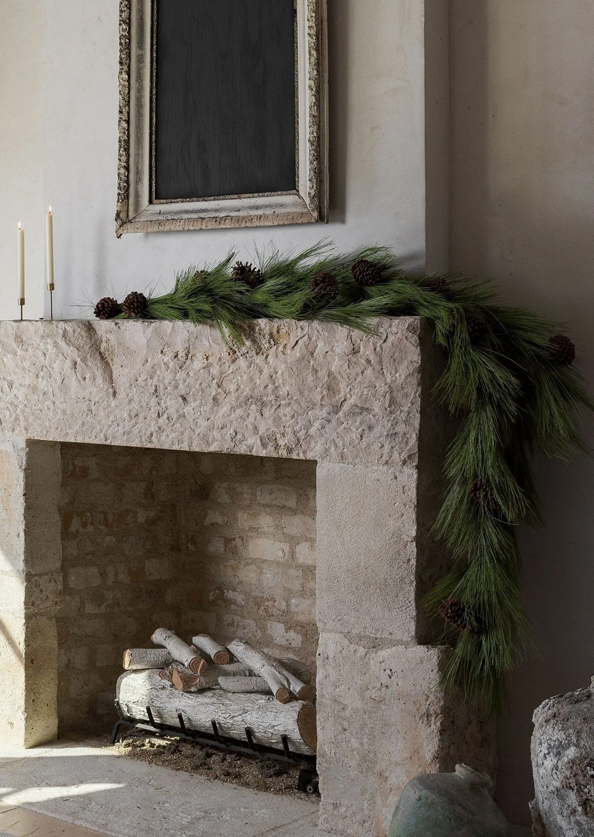 artificial longleaf pine garland draped on one side of a concrete fireplace