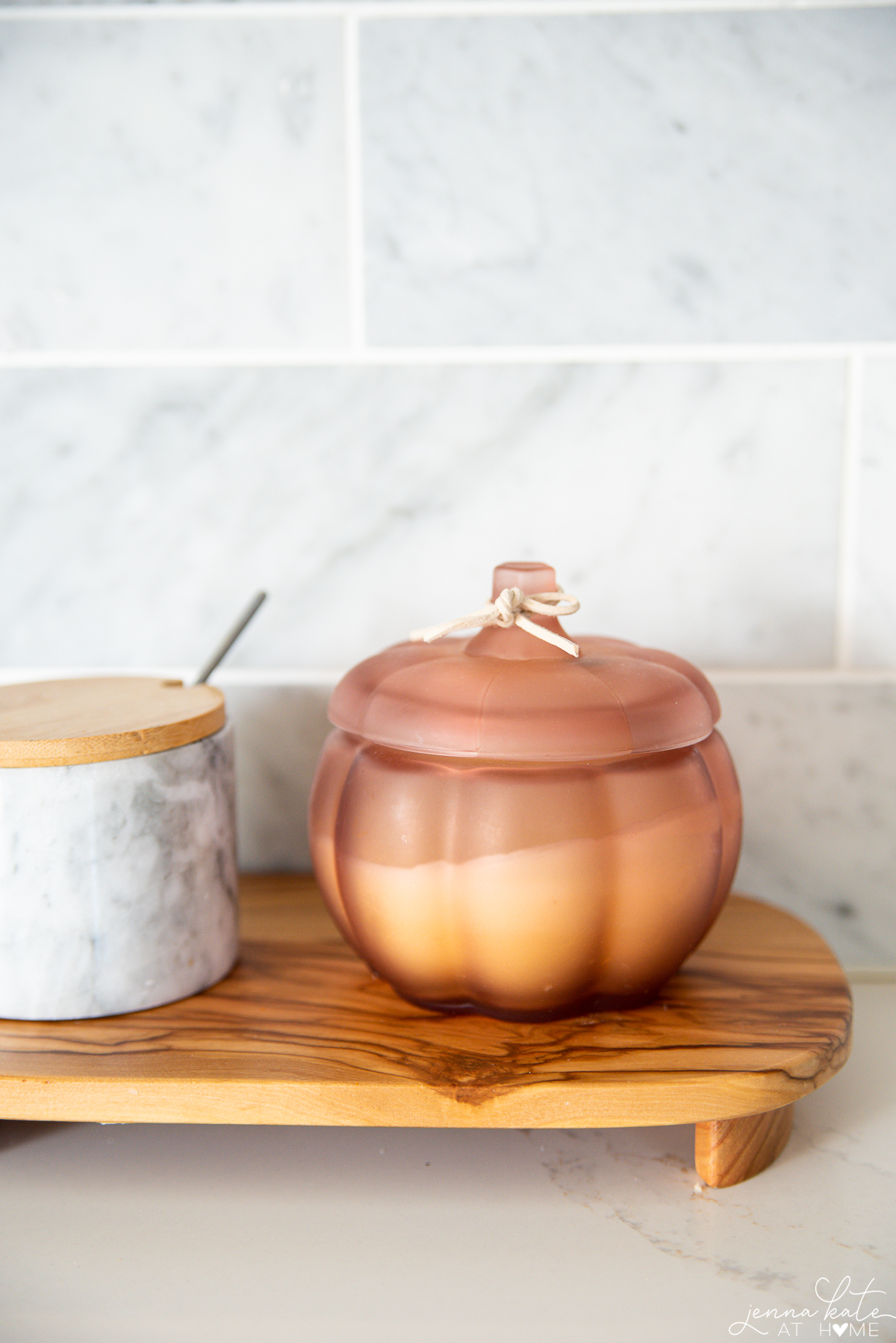 pink pumpkin shaped candle on a riser