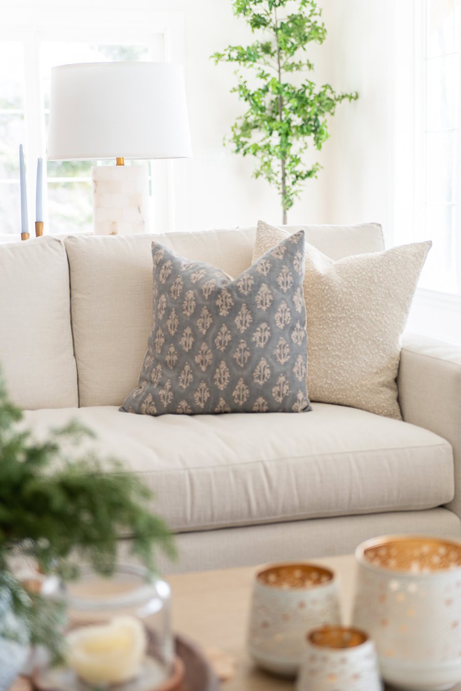 white couch with throw blue and cream throw pillows.