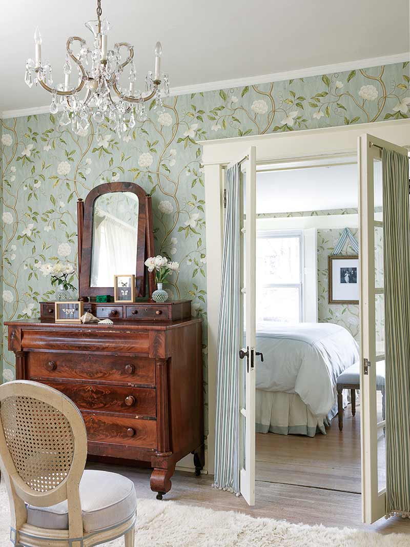 bedroom with dark wood dresser and green floral wallpaper
