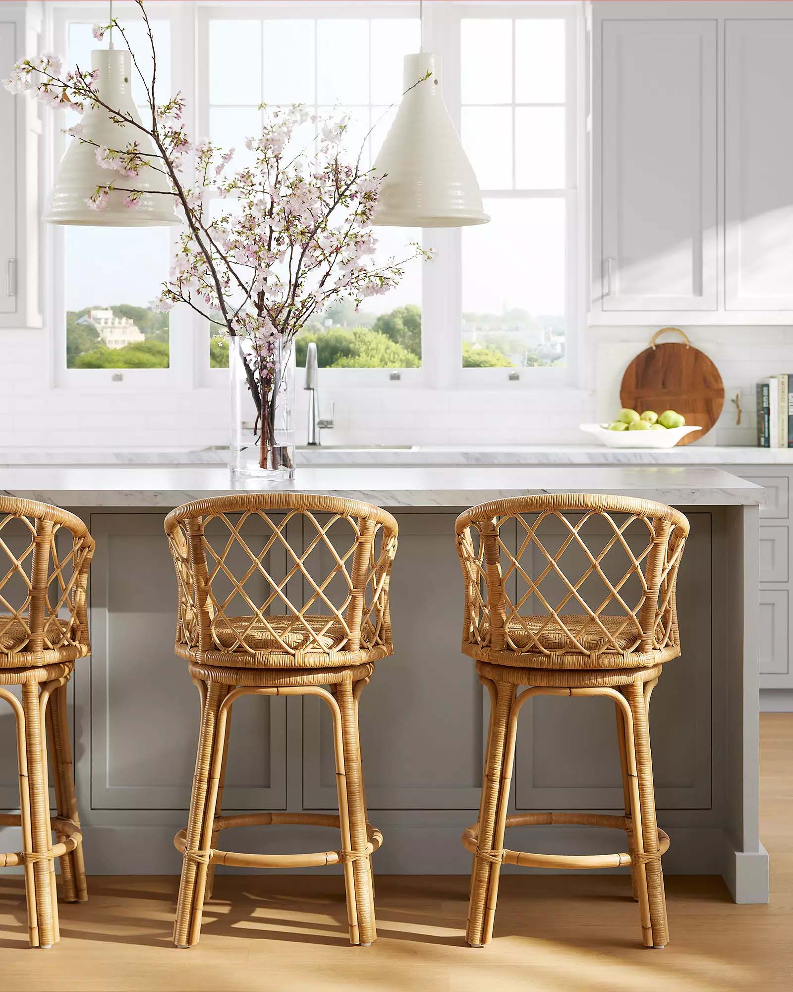 natural rattan swivel chairs at a gray kitchen island.