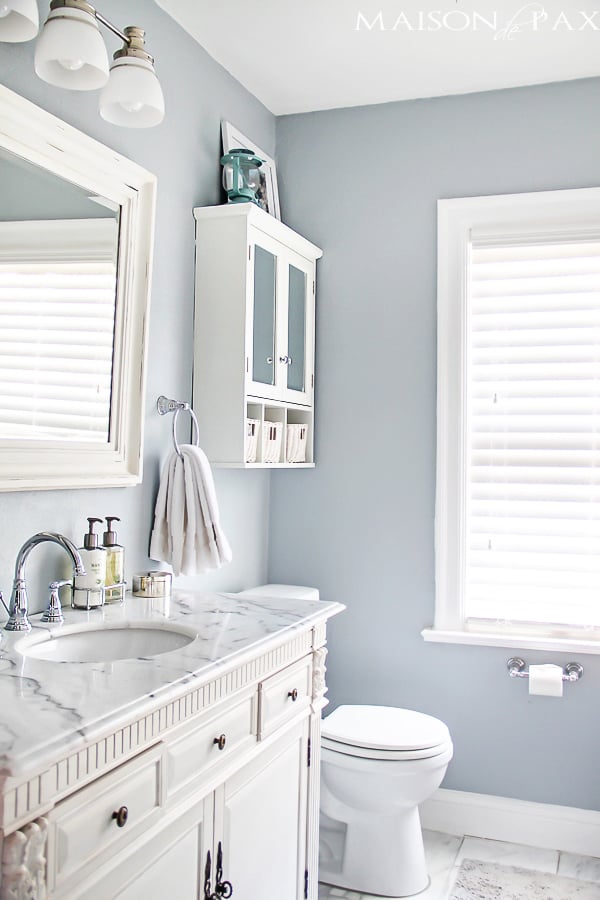 blue gray bathroom walls with white trim and cabinetry