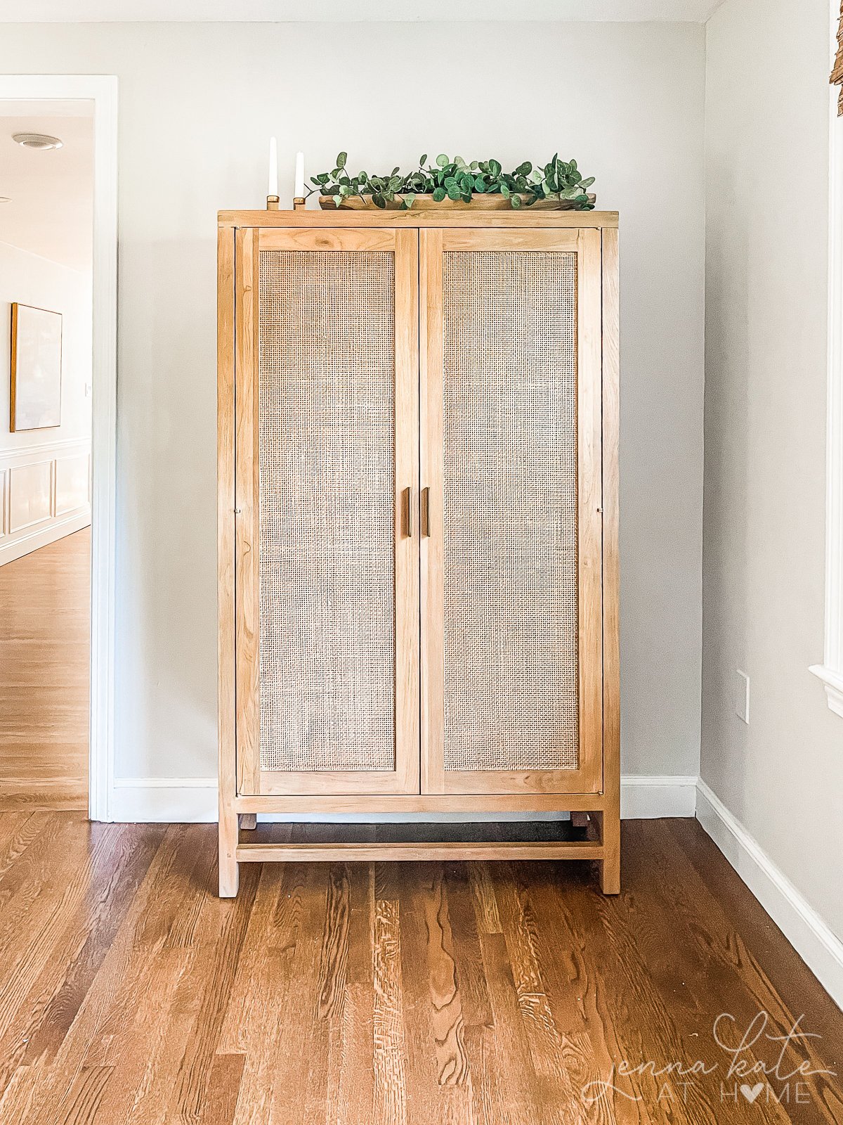 A tall credenza in the hallway against walls painted in repose gray