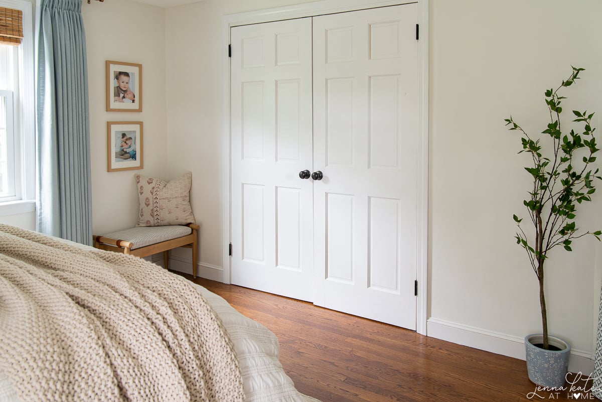 bedroom with white closet doors and warm white painted walls