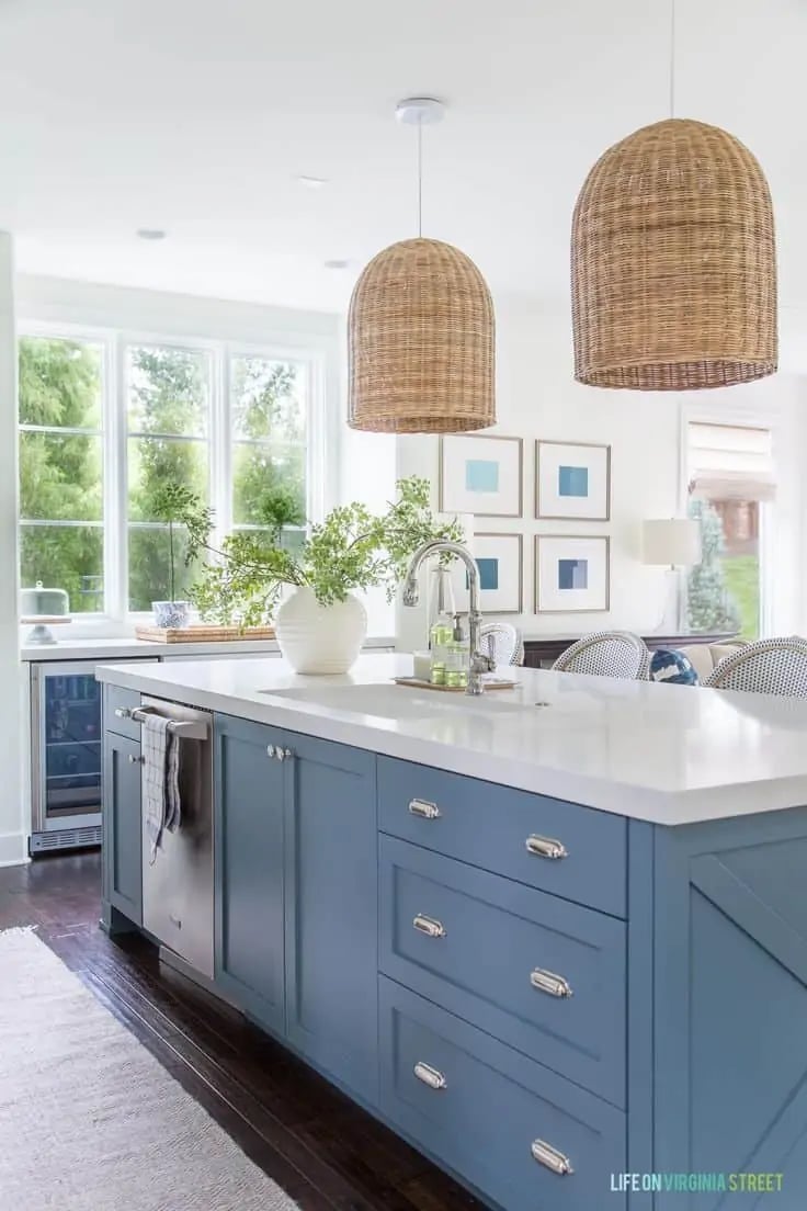 kitchen with BM providence blue island, white countertops and large rattan basket pendant lights
