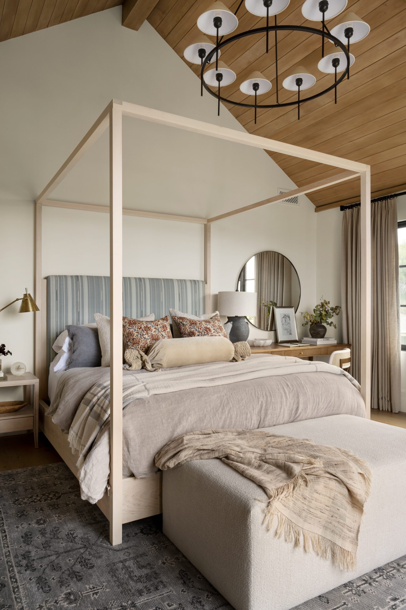 a styled bedroom with a large bench in front of the bed