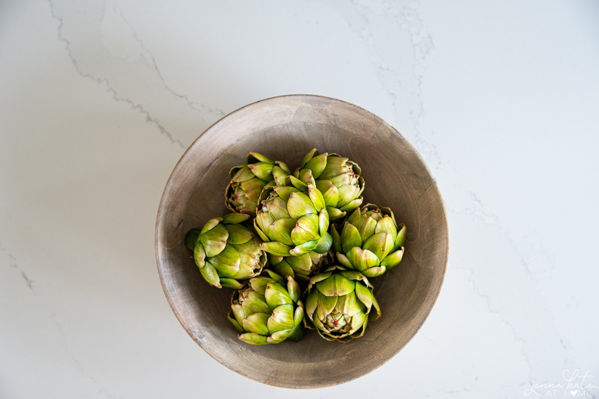 bowl of artichokes on a white quartz countertop