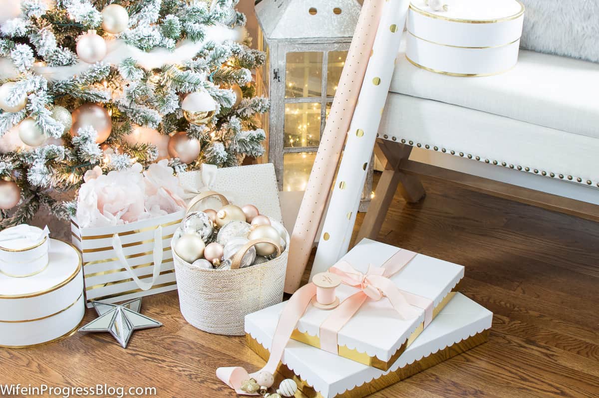 coordinating white and gold gift boxes in front of a Christmas tree