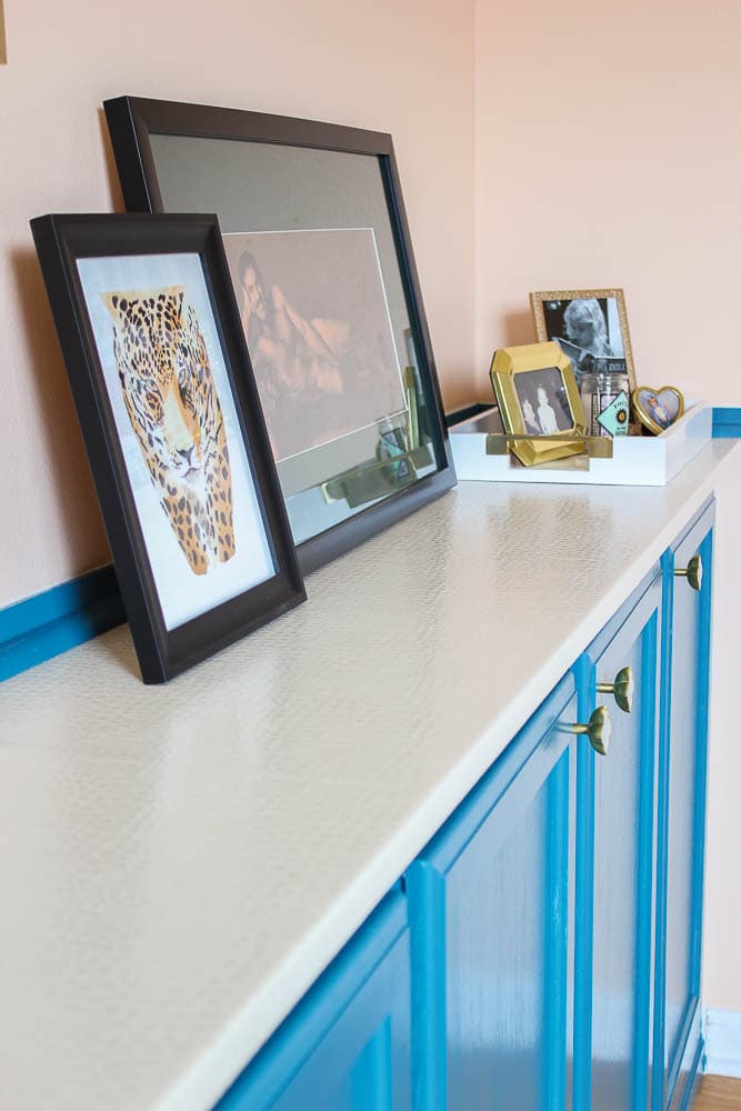 DIY countertop that looks like beige upholstery with picture frames sitting on top
