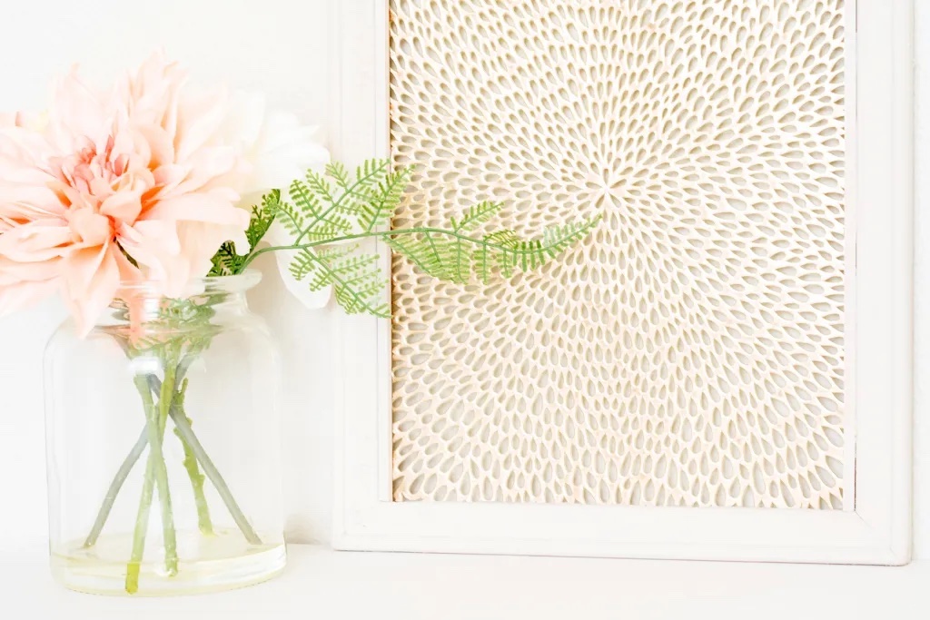 Gold abstract placemat framed sitting next to a flower in a vase