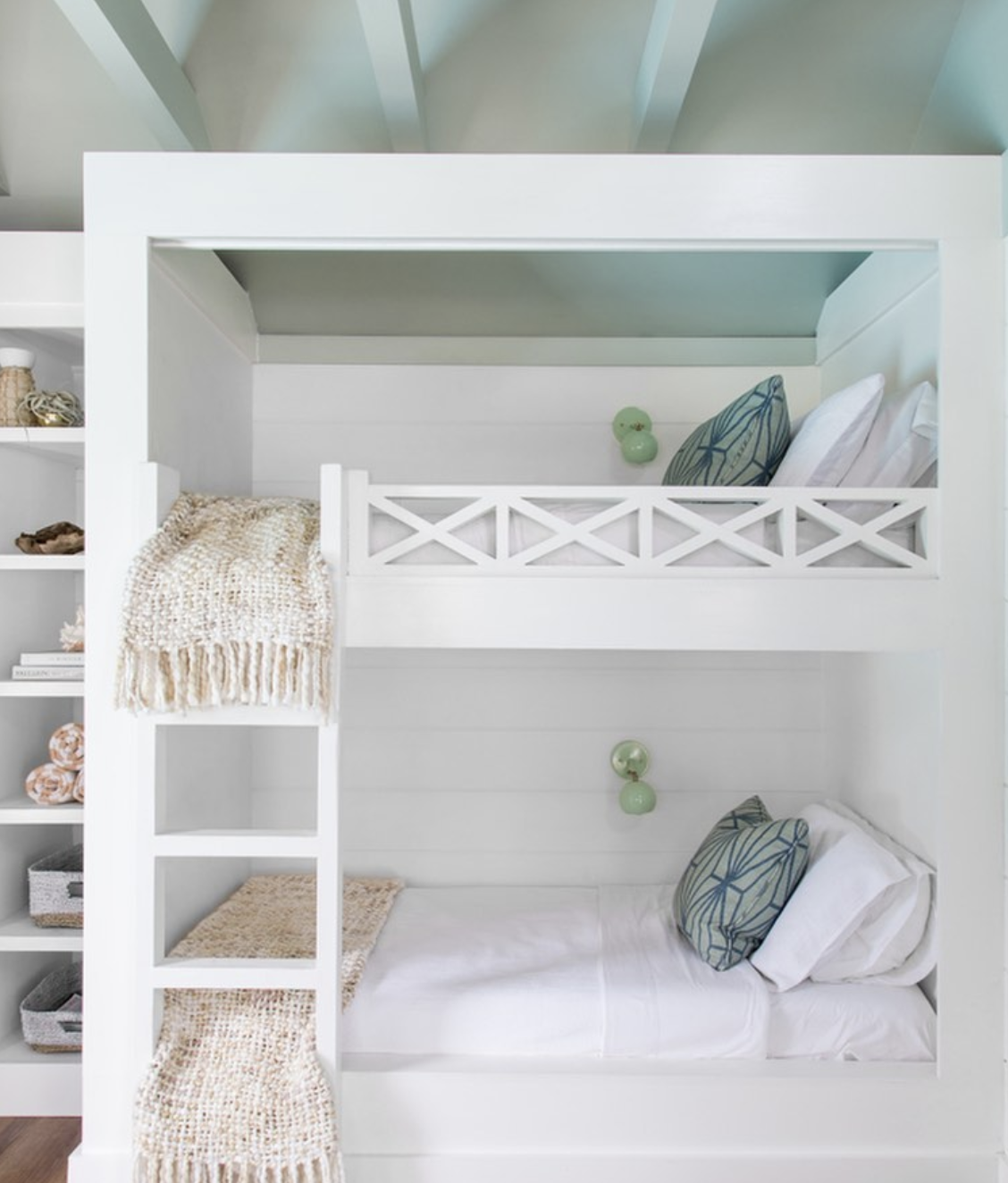 white built in bunk beds with the ceiling painted a soft sage green.