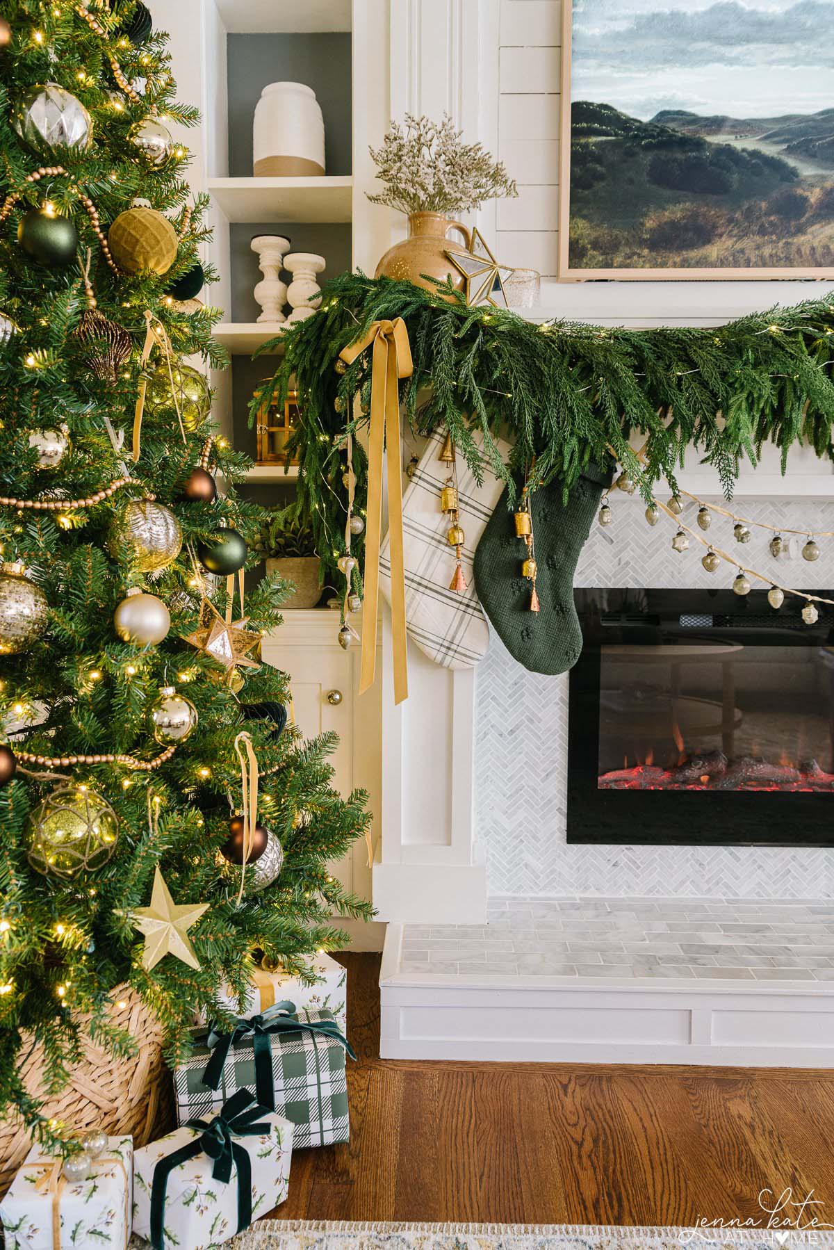 Norfolk pine garland draped over a mantel with mustard yellow ribbon, and green plaid stockings hung under the mantel