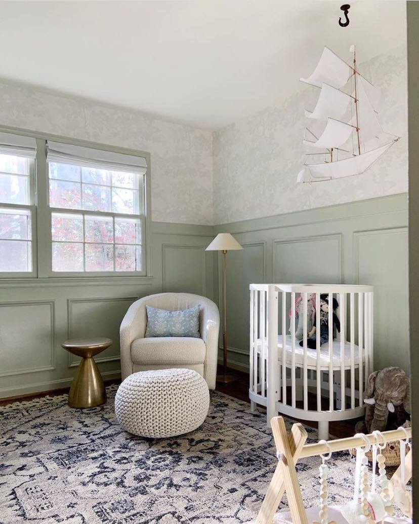 Picture frame wainscoting in a nursery painted Sherwin Williams Liveable Green.