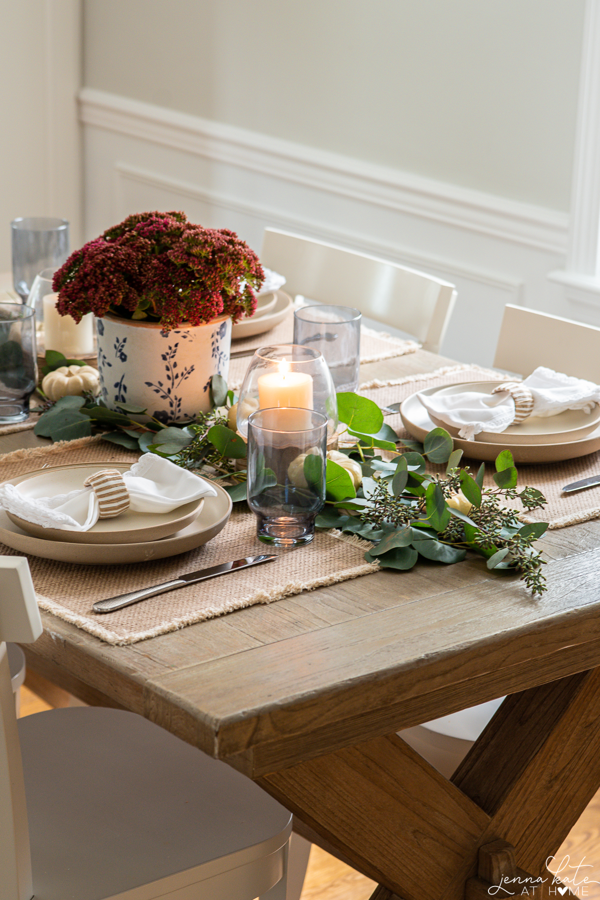 eucalyptus table runner with mini white pumpkins and table settings