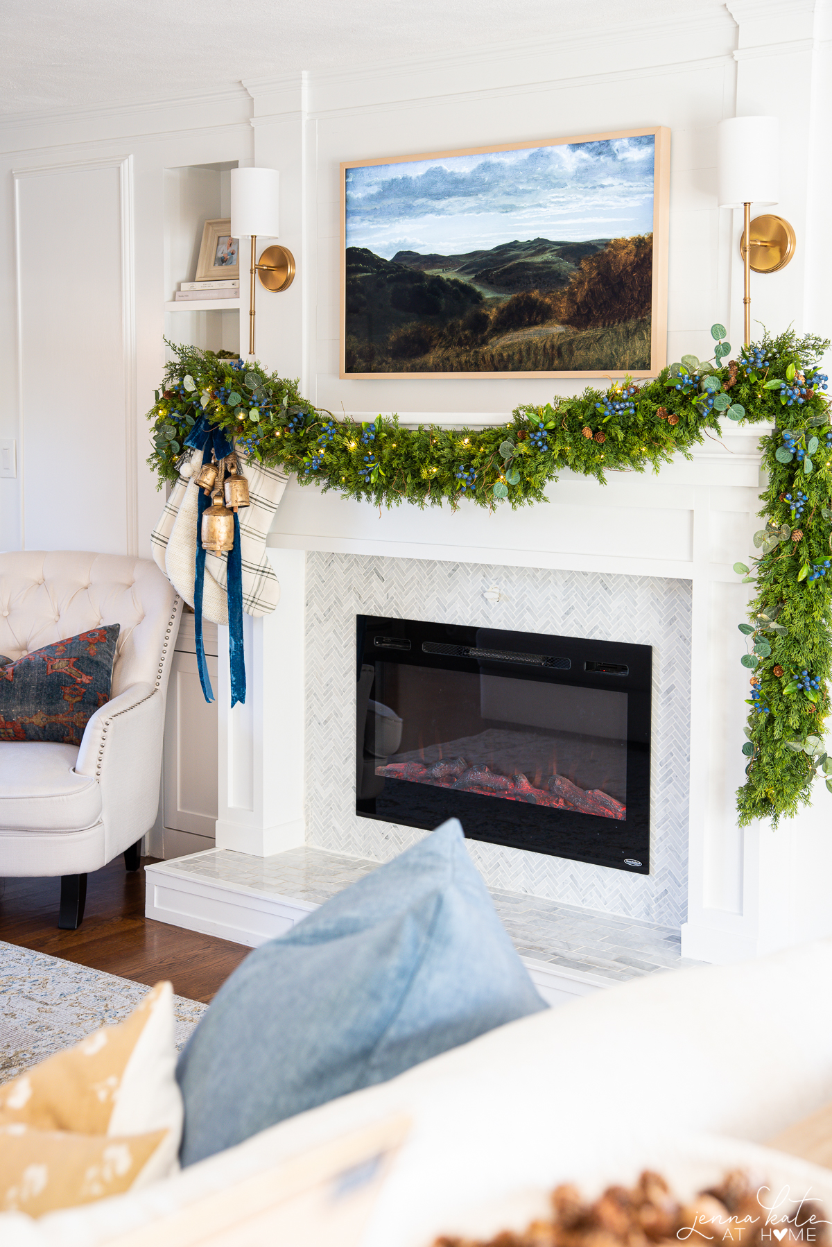 mantel with draping cedar garland with brass bells hanging from one corner