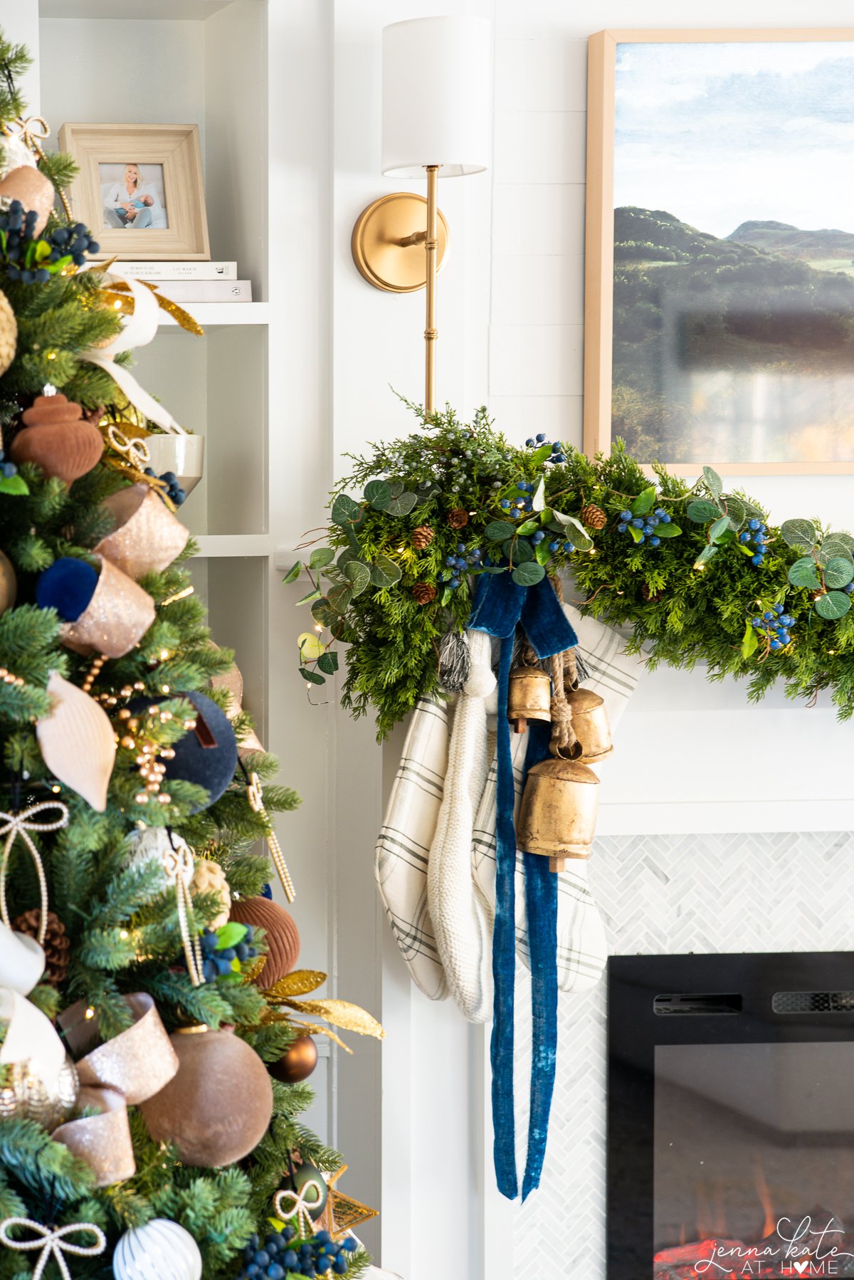 sconce over the fireplace with garland with bells and stockings below