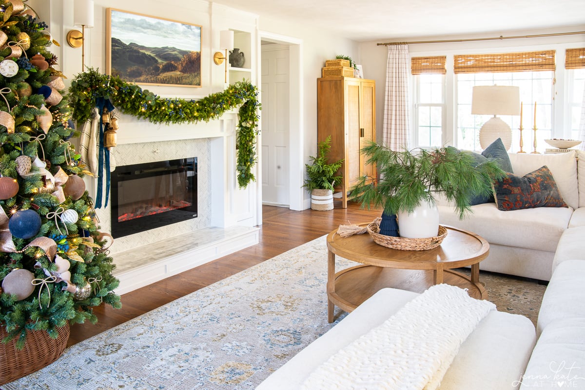 living room with coffee table, white couch, fireplace and decorated Christmas tree