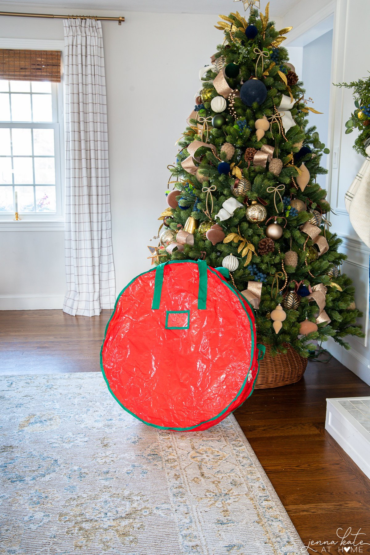 wreath storage bag leaning against a Christmas tree.
