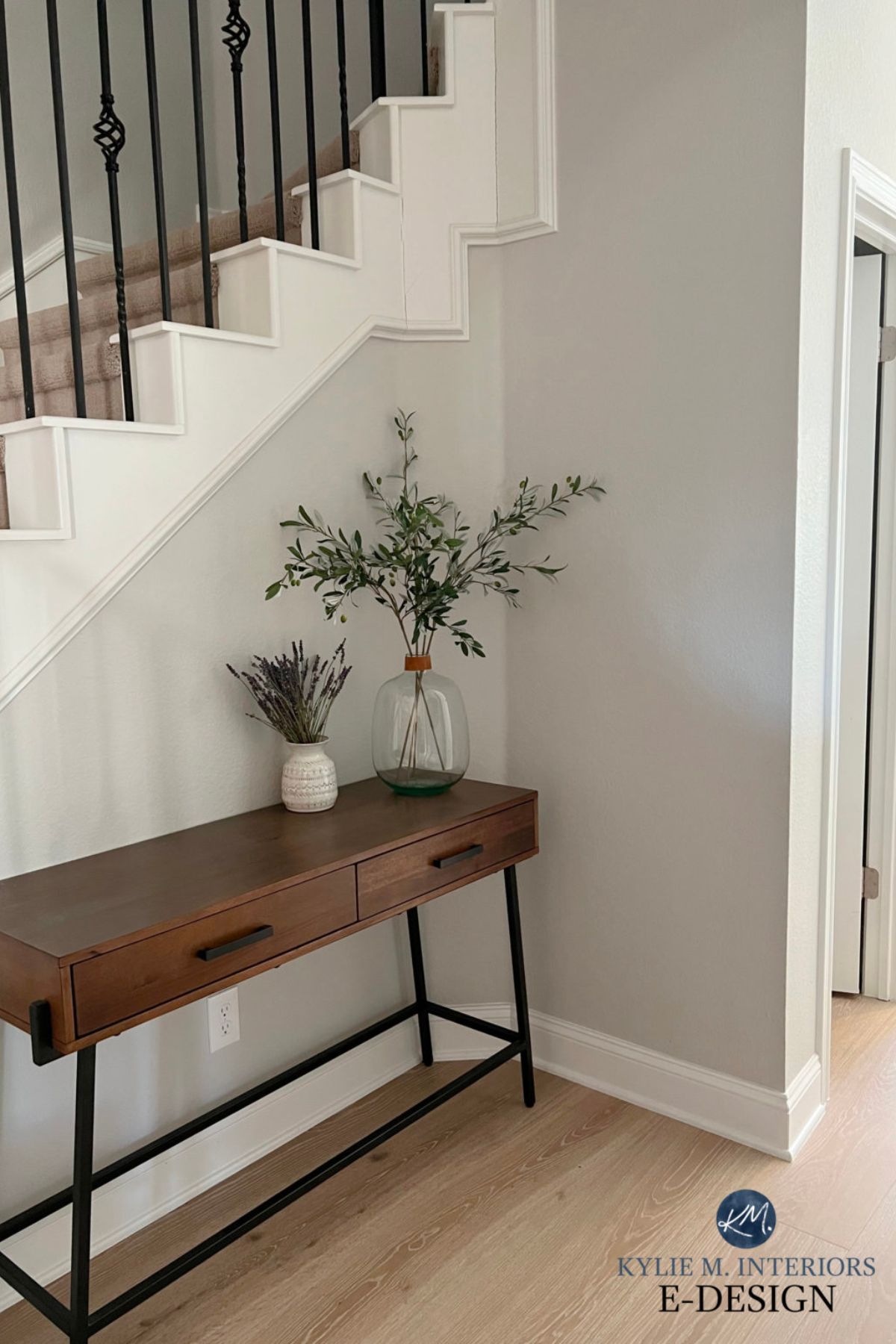 An entryway painted with crushed ice on the side of a staircase with a console table underneath.