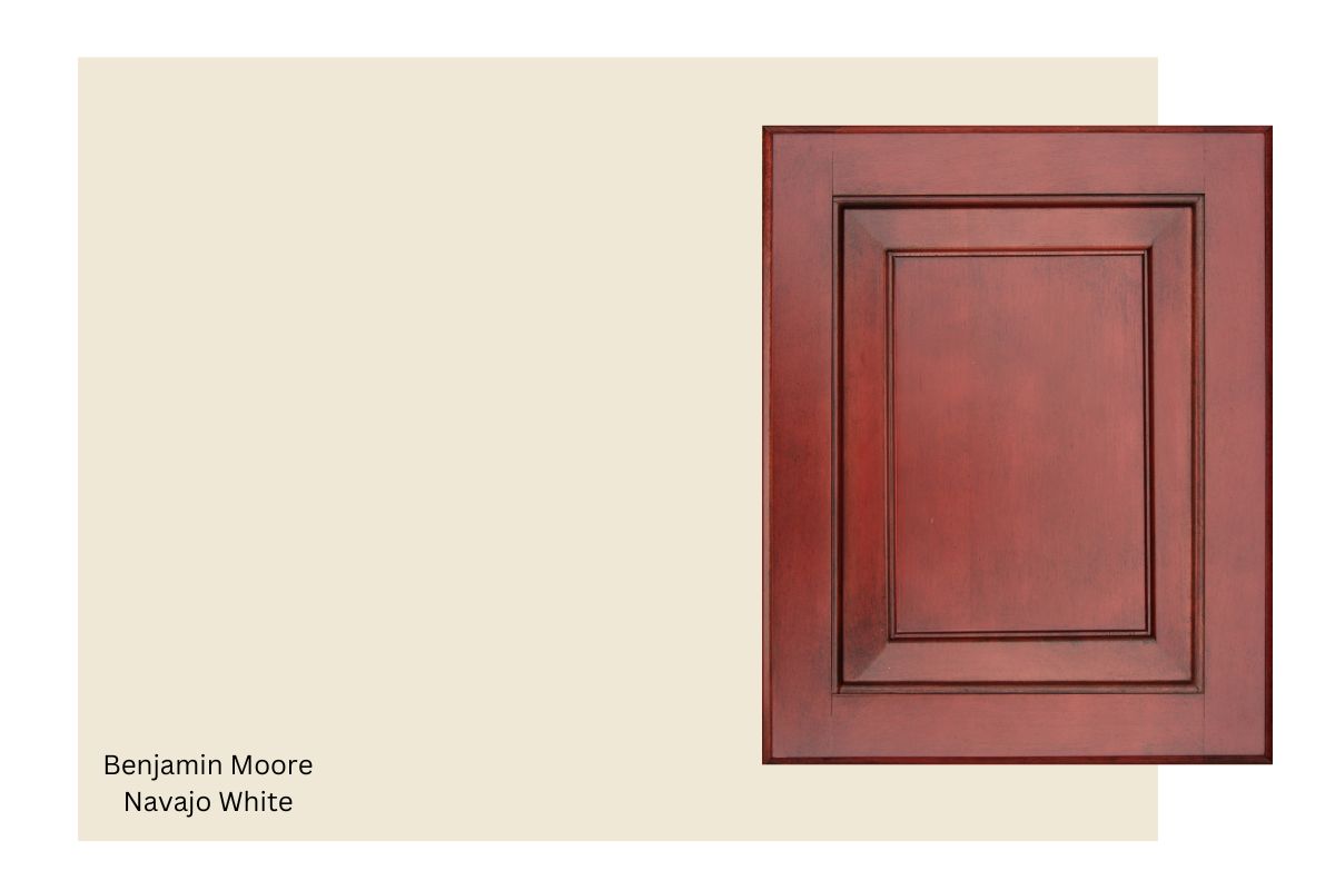 cherry wood cabinet with a swatch of Benjamin Moore Navajo White.