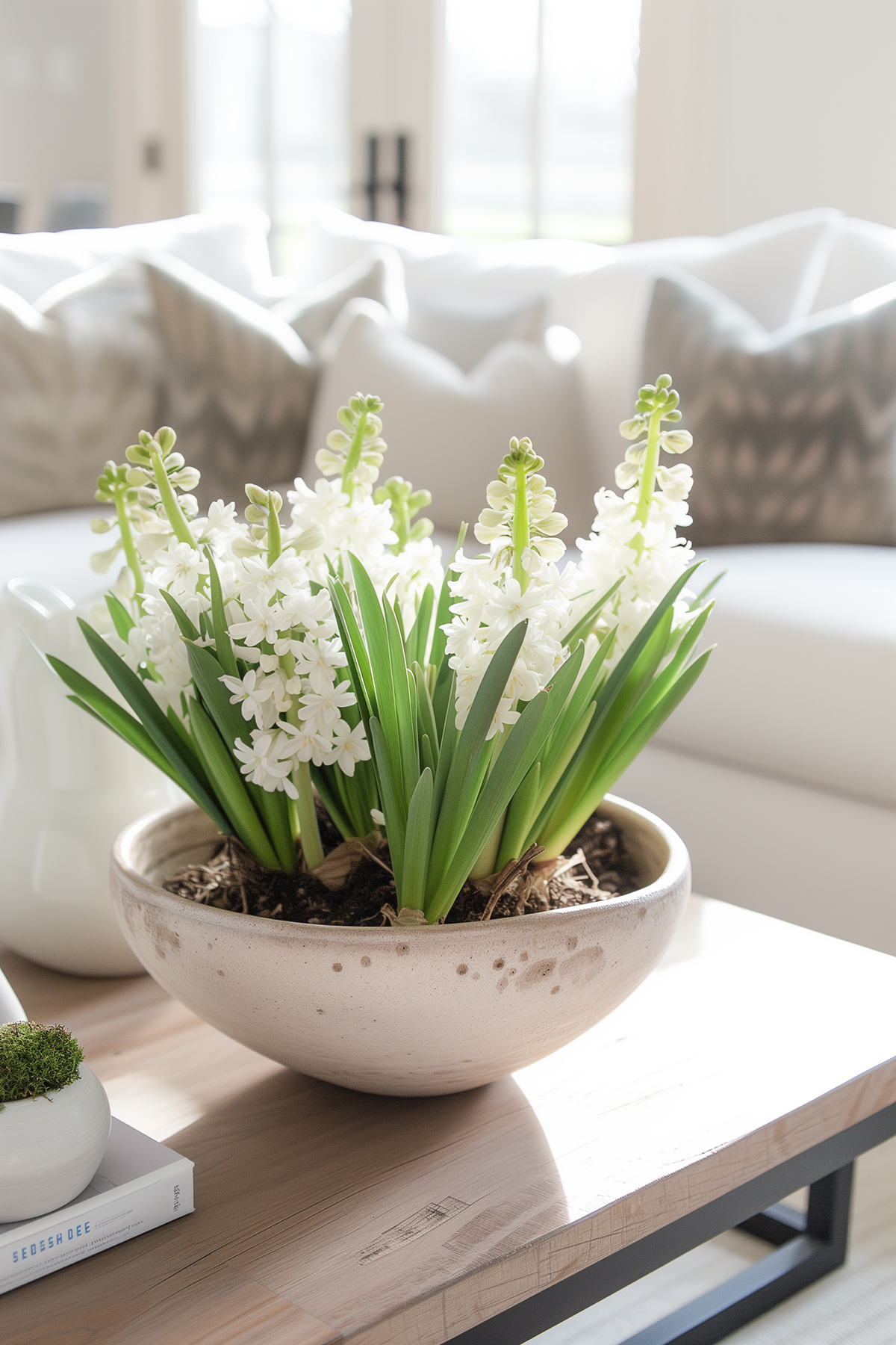 bowl of white hyacinths on a coffee table.