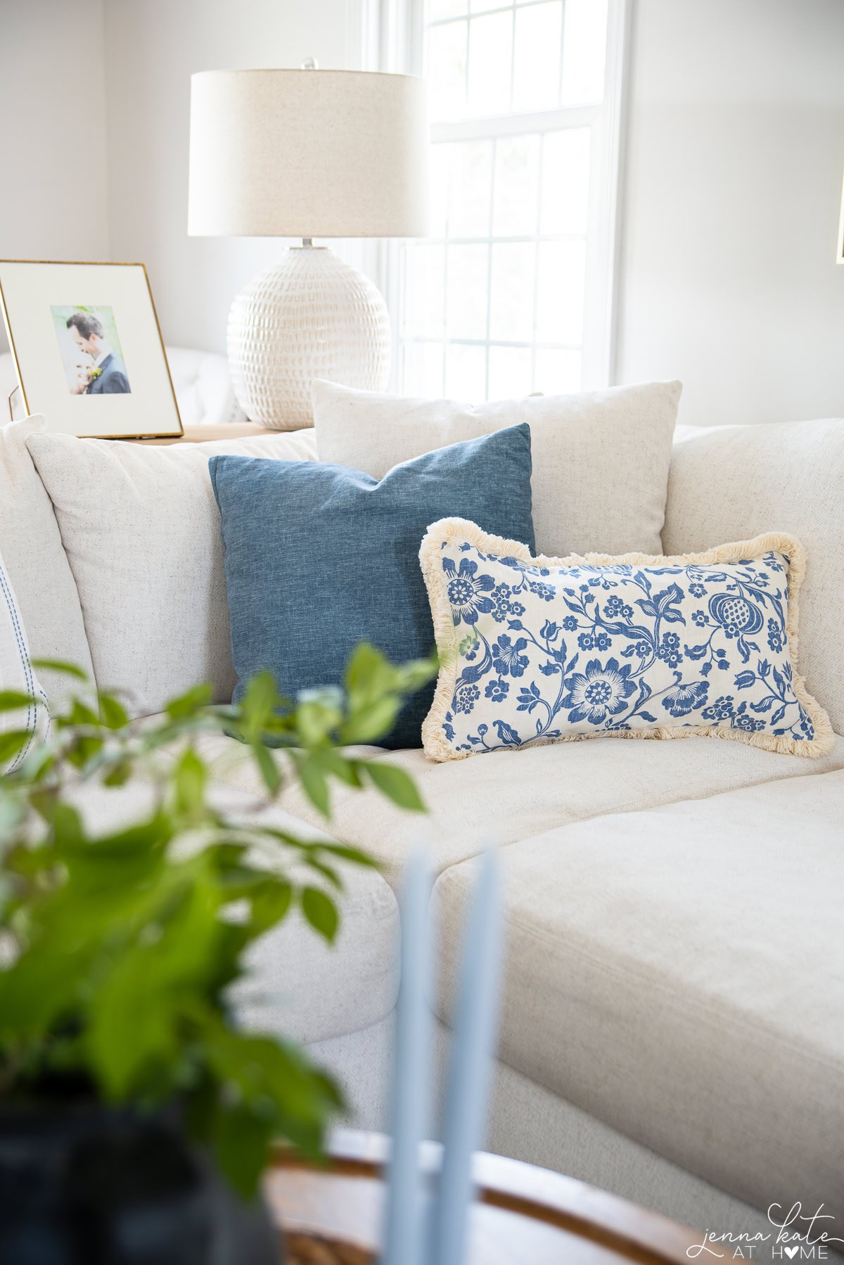 white couch with blue and white throw pillows.