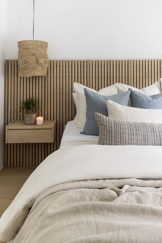 bedroom with wooden slatted wall and neutral colors.