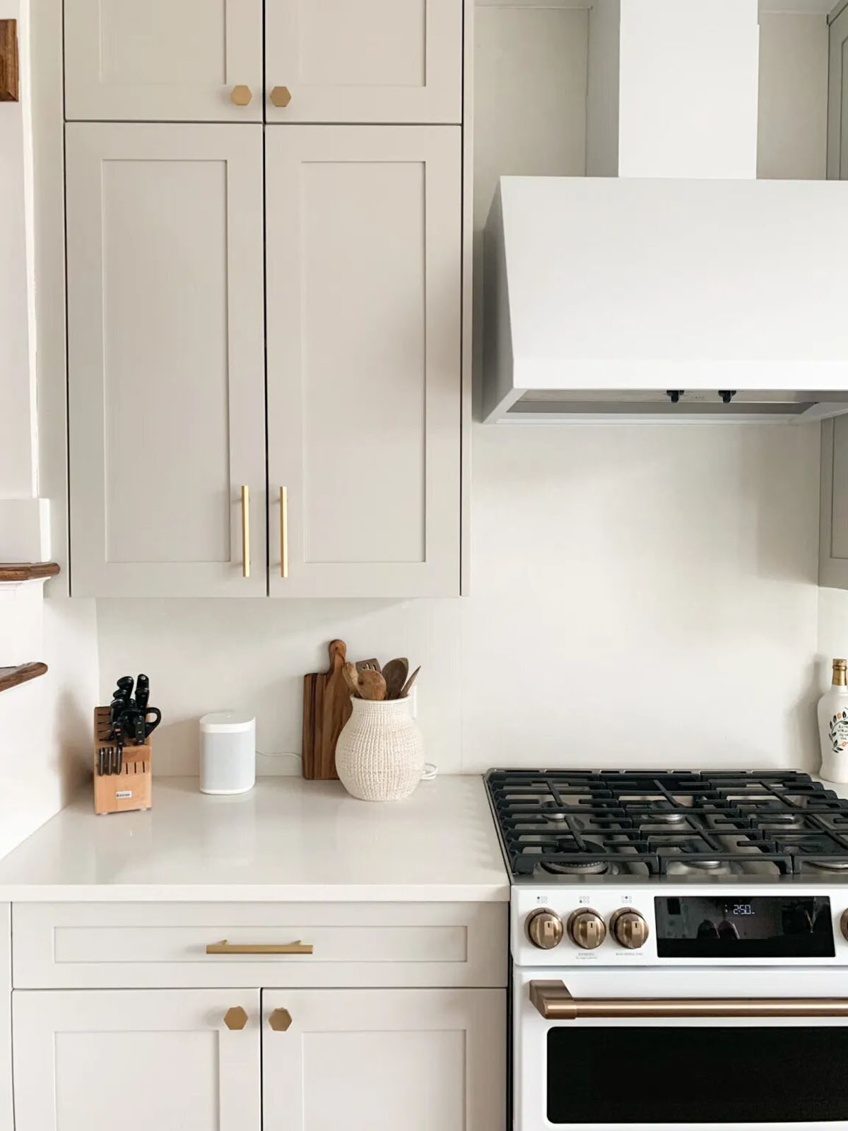 Sherwin Williams Agreeable Grey cabinets with a creamy white wall color and gold hardware.