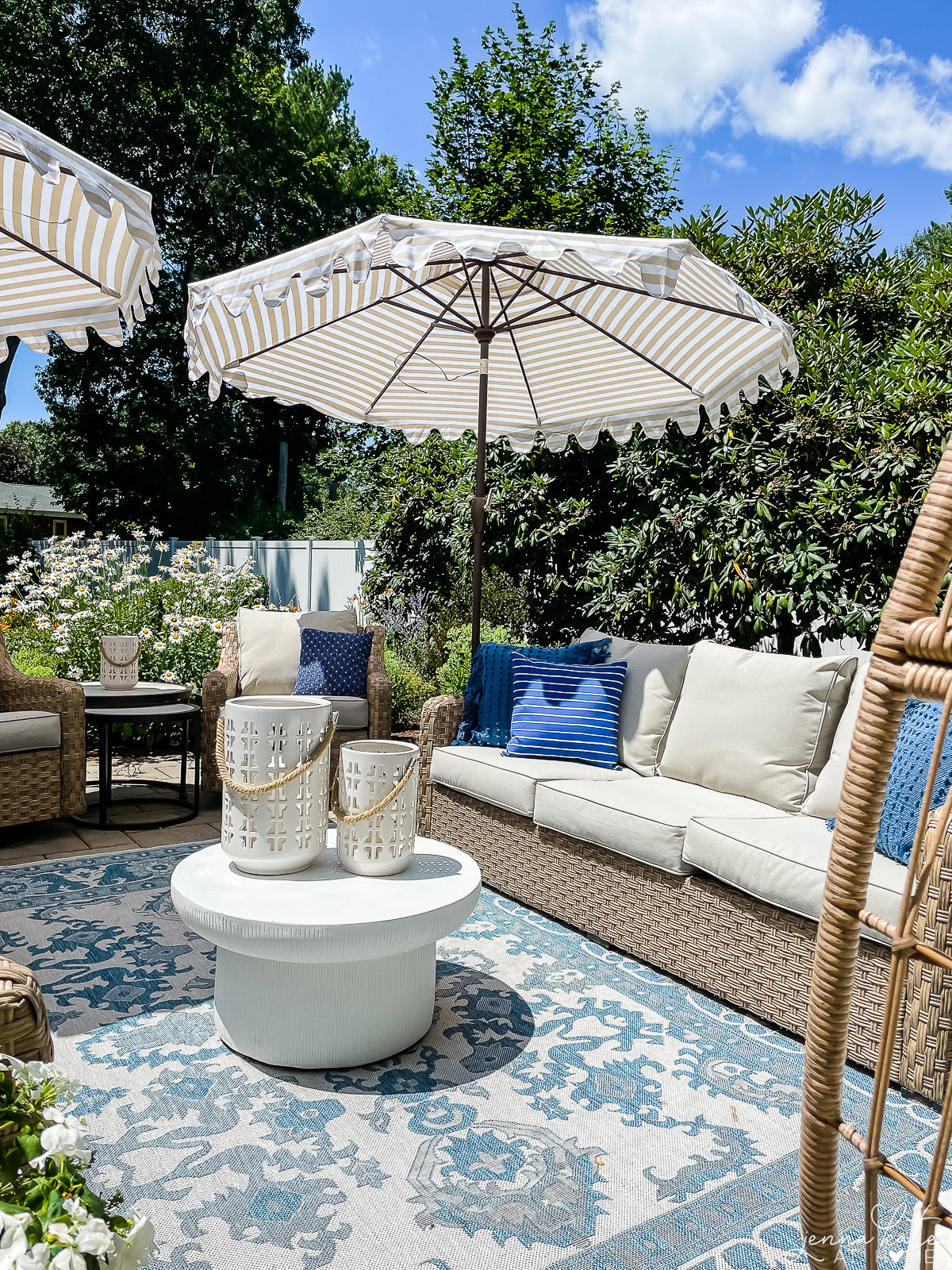 patio with blue rug, wicker furniture and concrete coffee table.