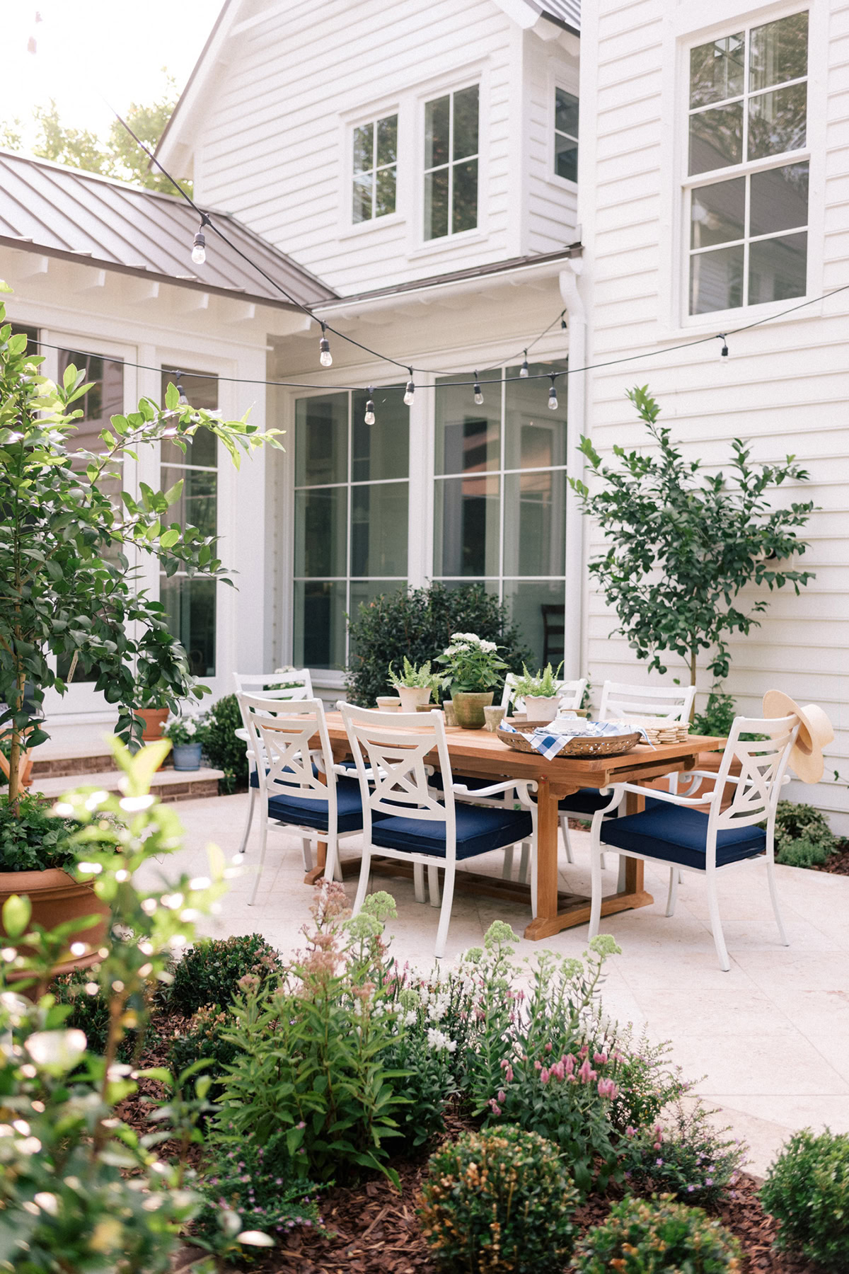 patio with a dining table and overhead string lights.