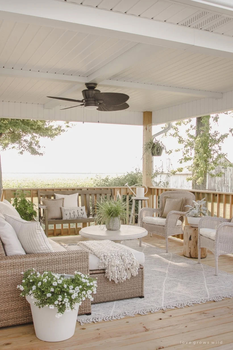 covered deck with lots of pretty plants and flowers.