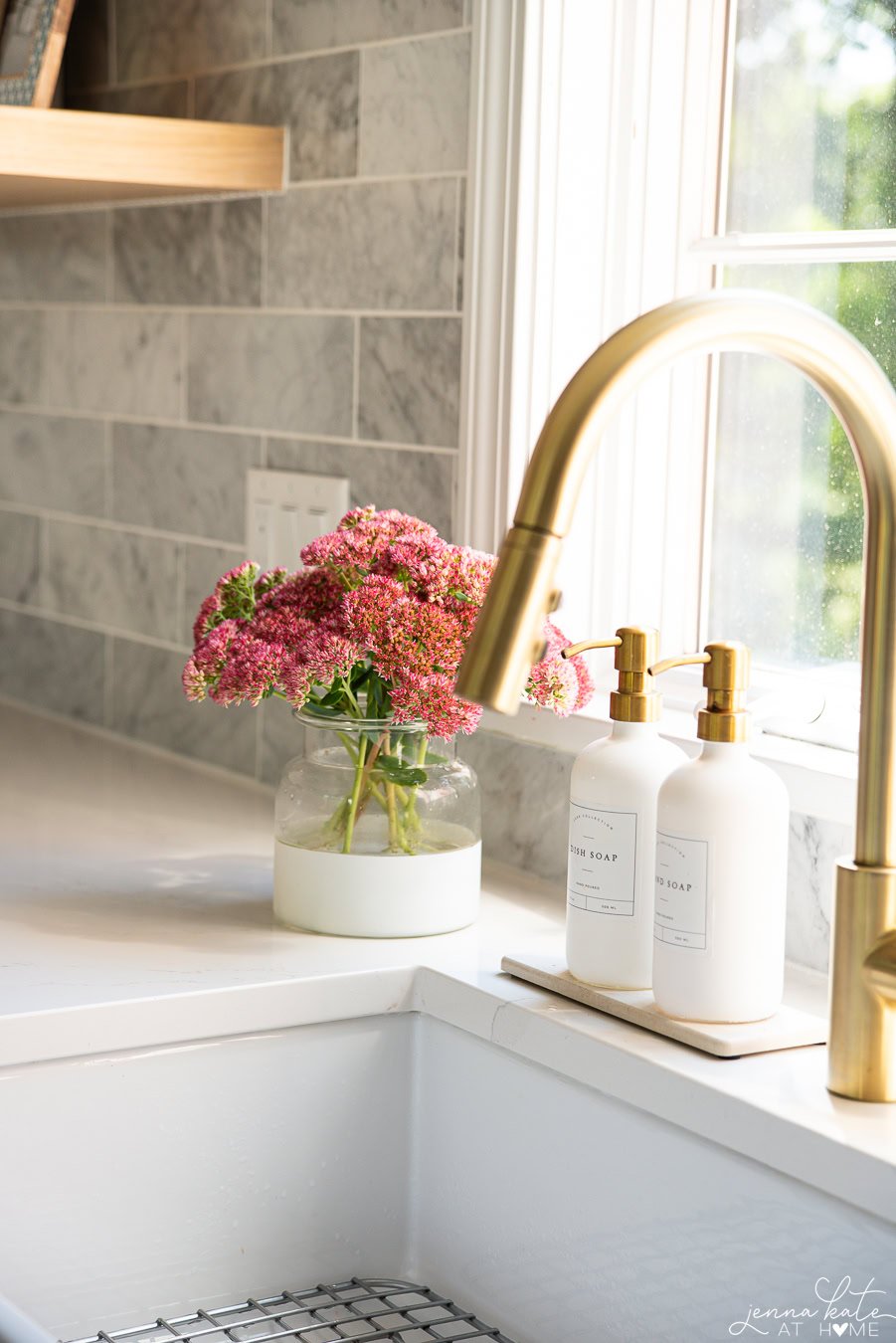 vase of pink sedum next to the sink.