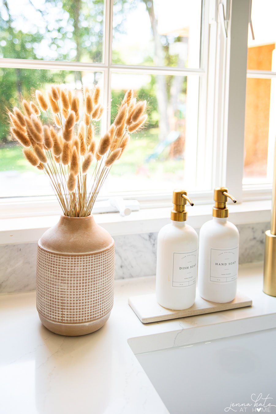 small vase of bunny tail stems next to the sink for fall.