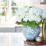 kitchen island with blue vase filled with flowers.