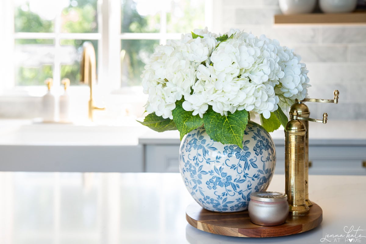 blue vase of hydrangeas styled on a kitchen island.