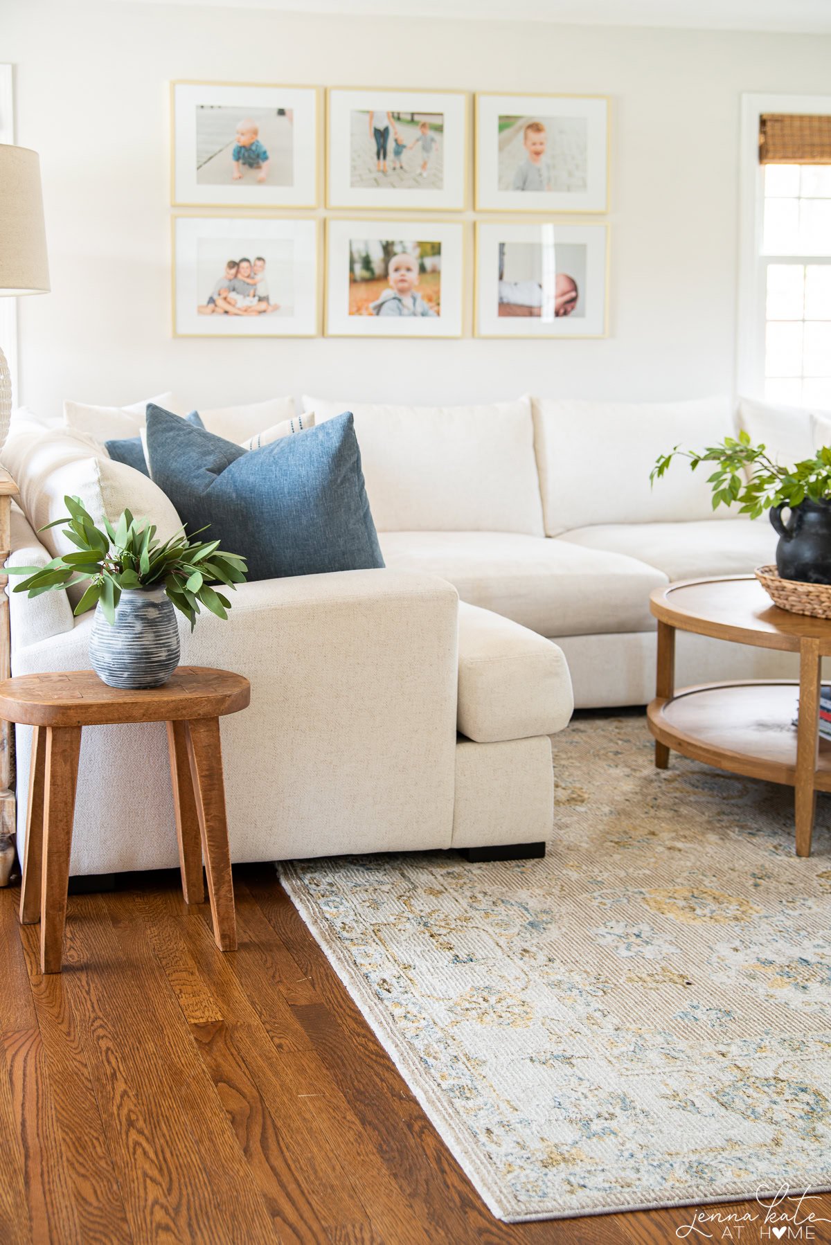 living room with a grid of family photos on the wall over the couch.