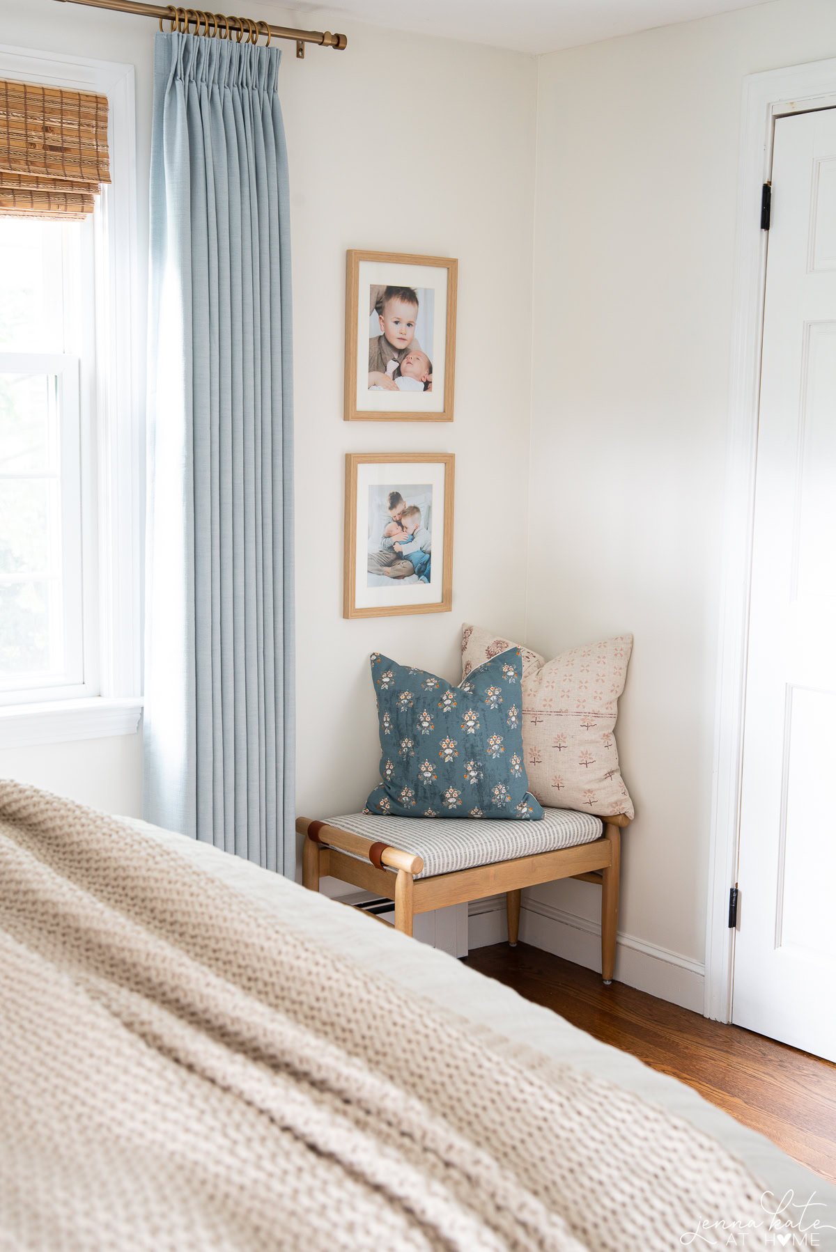 corner of a bedroom with a narrow wall with two stacked family photos.