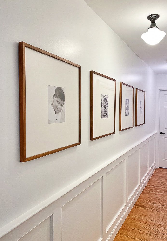 family photos in large frames in a hallway.