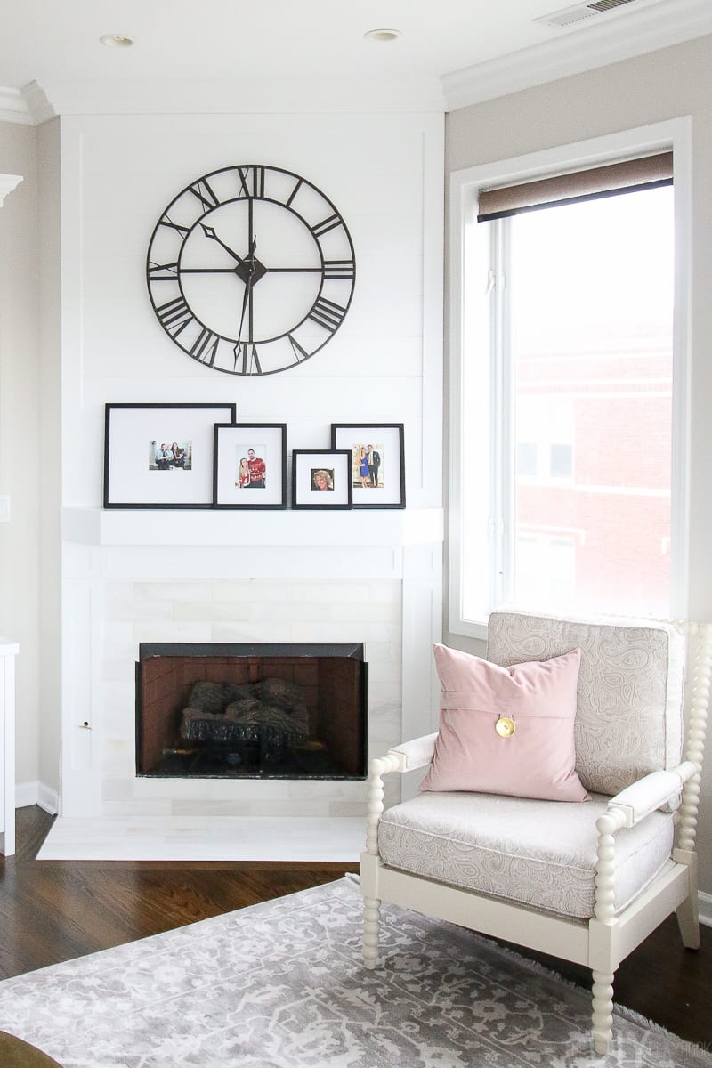 family photos in black frames displayed on a white mantel.