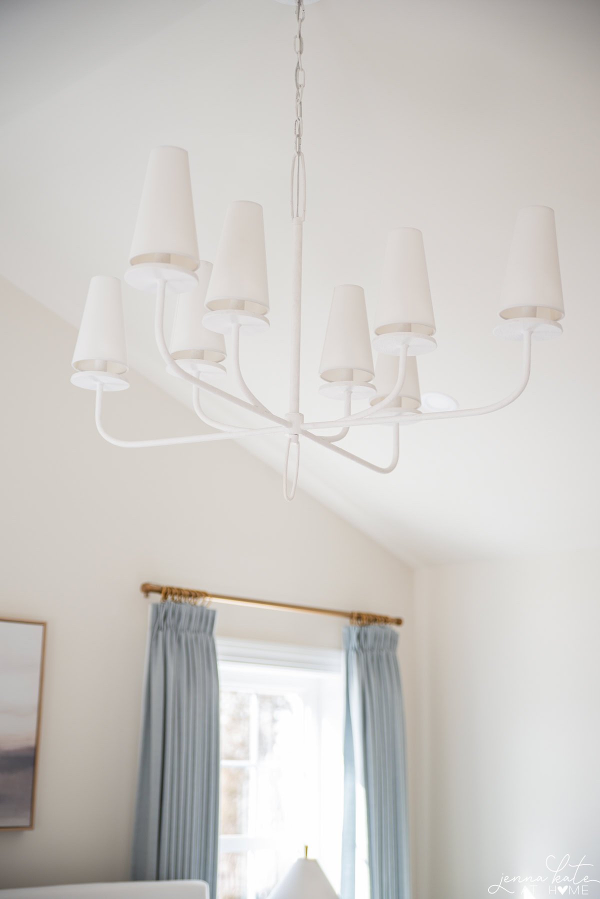 white chandelier on vaulted bedroom ceiling.