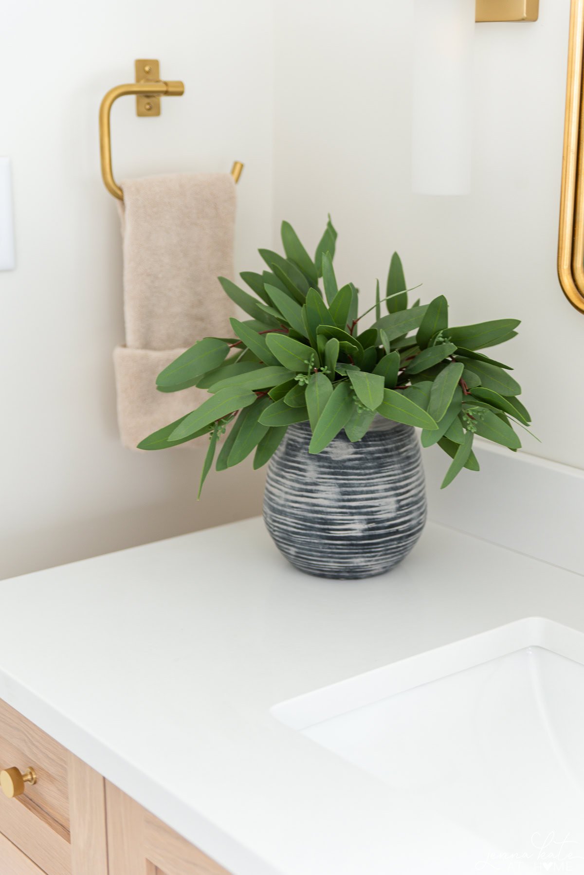 Close up of white quartz countertops in a modern primary bathroom.