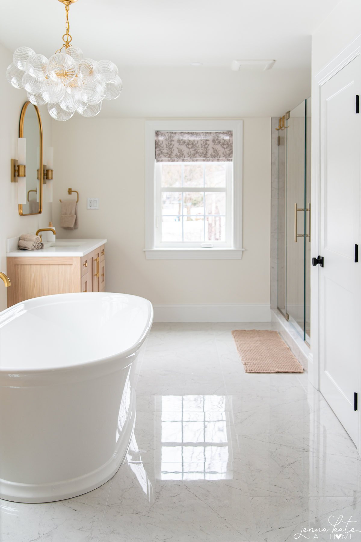 Full view of modern primary bathroom with soaking tub, vanities, shower, and custom lighting.