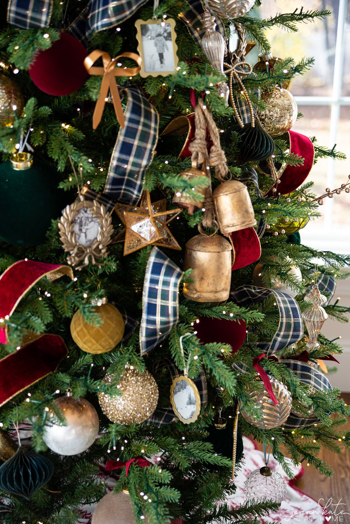 close up of red and gold ornaments on the tree, including a large cluster of bells.